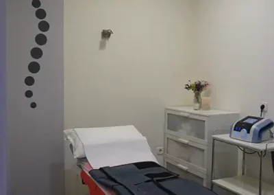Camilla preparada con equipo de presoterapia y aparato médico en consulta.