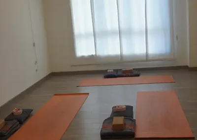 Sala de yoga con esterillas distribuidas para grupos reducidos